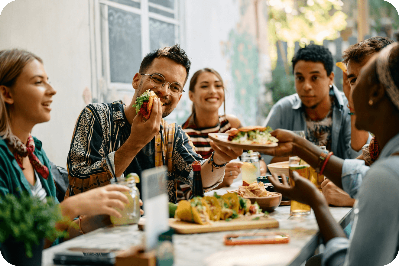 Friends sharing a meal, representing household-level audience insights for precise ad targeting