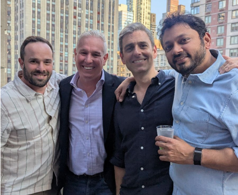 AdsLoom.net executives posing with a client at an NYC rooftop party.
